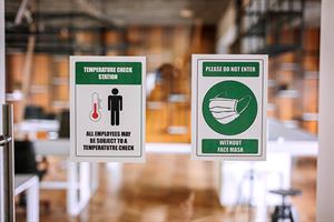 Social distancing and mask signs on a door