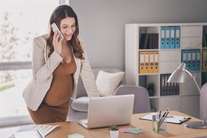 Pregnant person at laptop and on phone