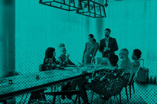 Group of people sat and stood around a table