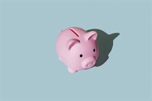 Pink piggy bank on blue background