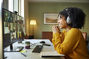 Smiling woman taking notes while on video call