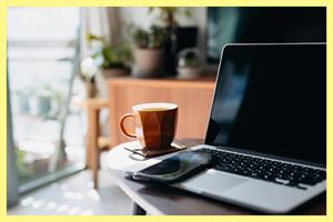 Laptop, phone and coffee cup on a table