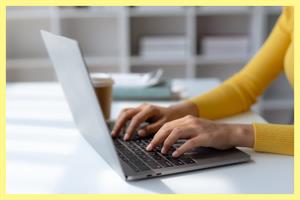 Hands typing on laptop