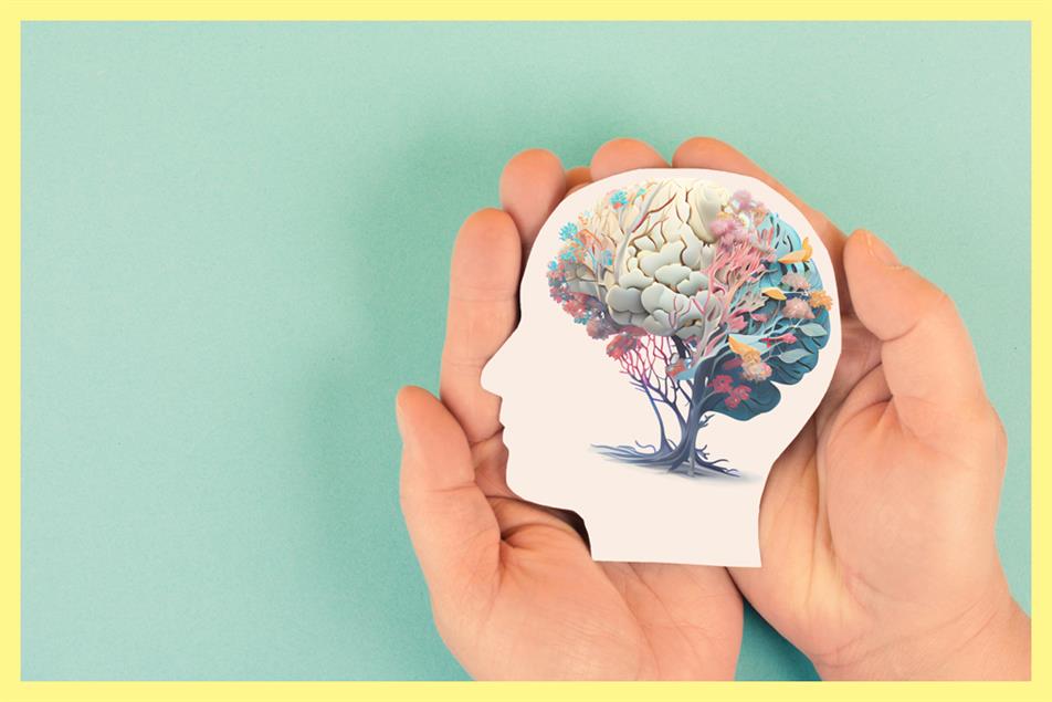 Hands holding image of brain as a tree in a head 