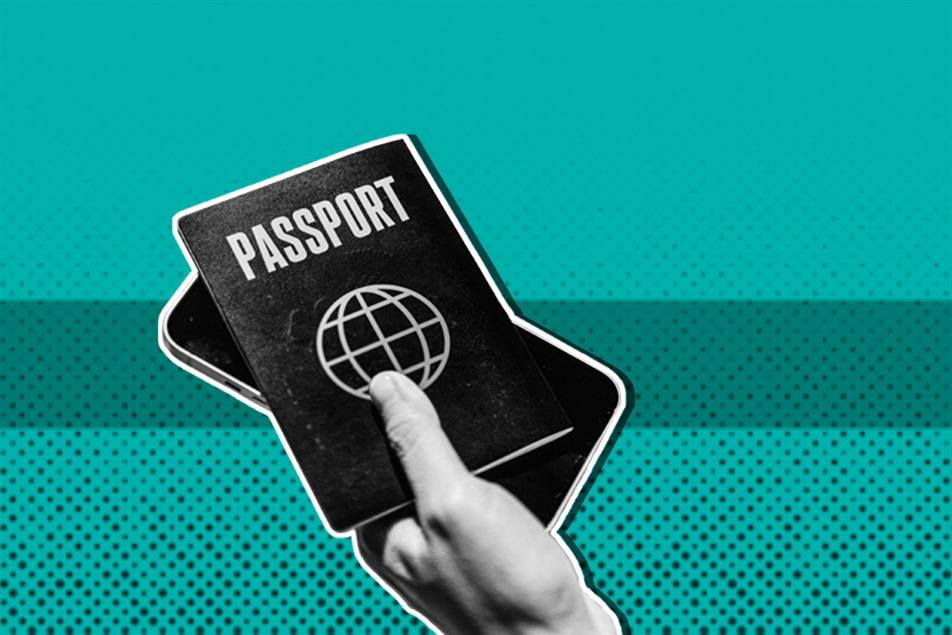 Close up of a hand holding a passport and phone