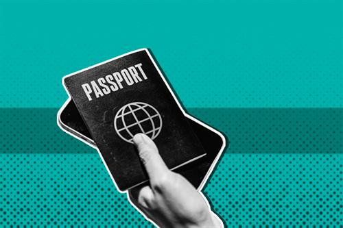 Close up of a hand holding a passport and phone