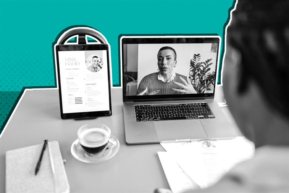 Person sat at a desk in front of a laptop and pad