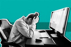 Person sat in front of a computer screen with head in their hands