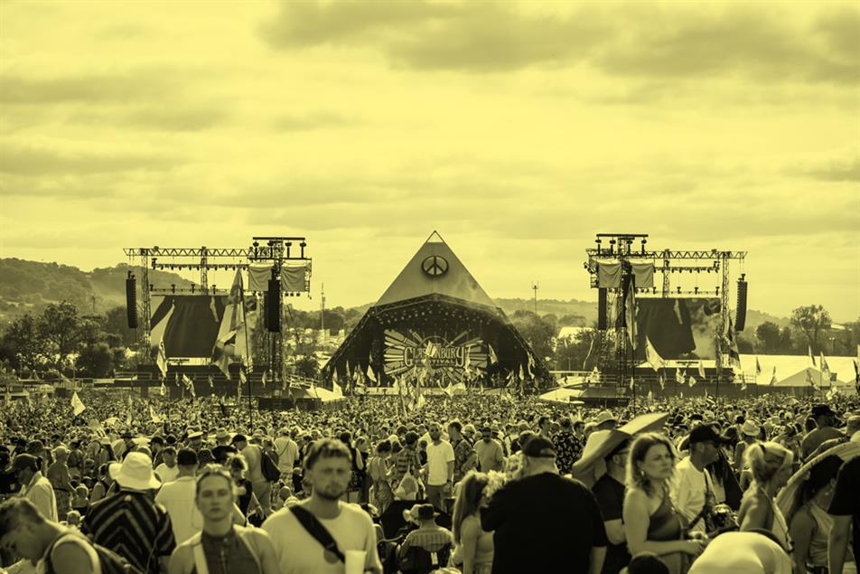 Image of a crowd of festival attendees in front of the pyramid stage at Glastonbury