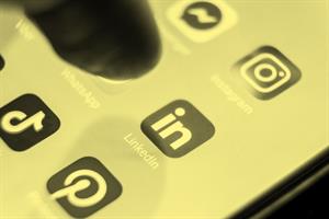 Close up of finger pressing LinkedIn application on mobile phone