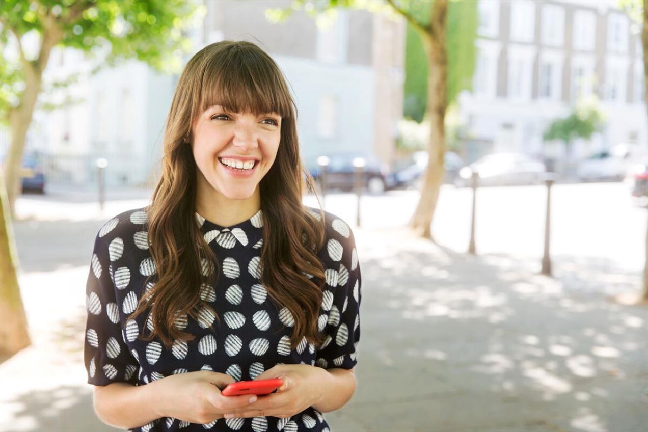 Woman smiling holding phone