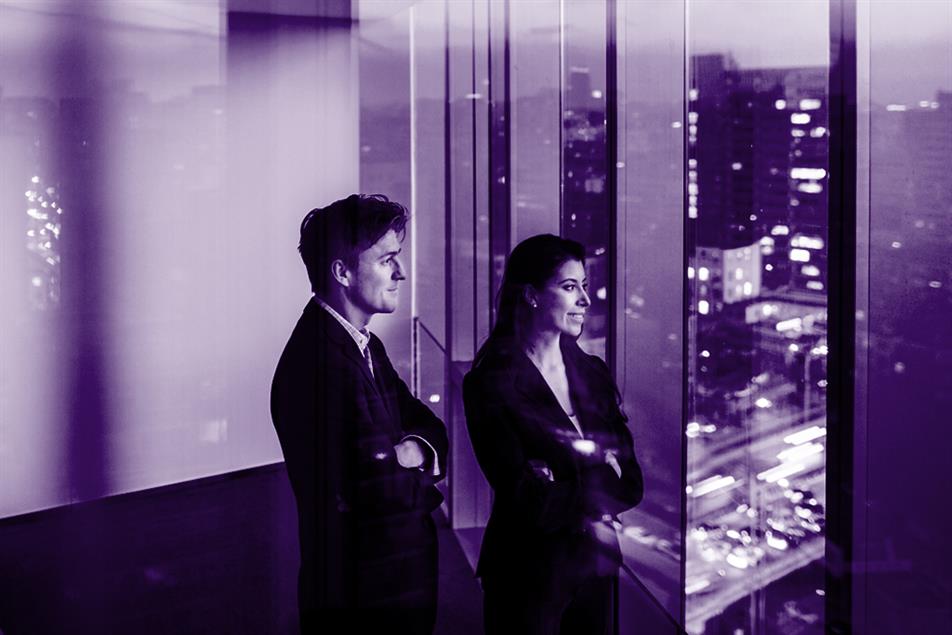 Two people with arms crossed looking out of the window