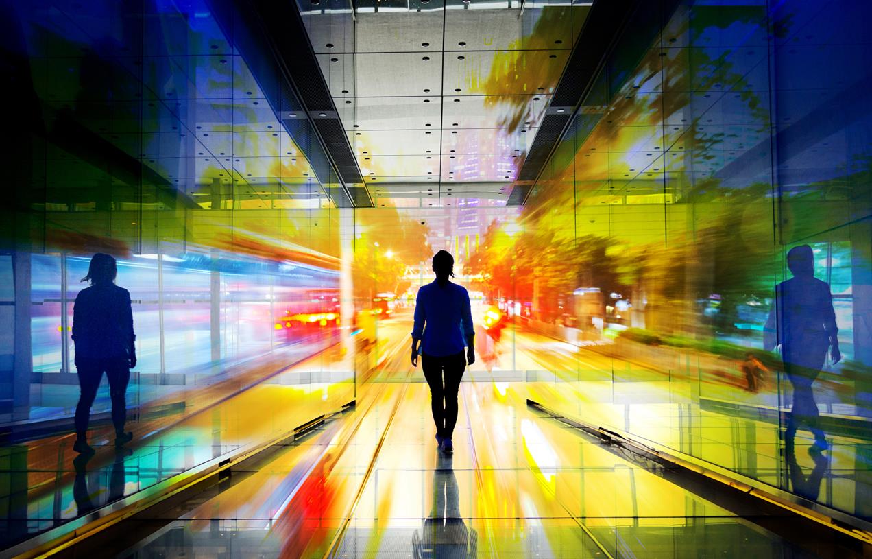 Silhouette of a woman walking down a colourful corridor