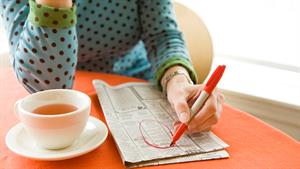 Jobseeker circling a job advert in a newspaper 