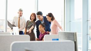 Group of employees gathered around a computer