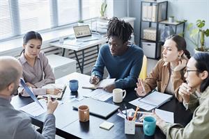 A group of young people around a meeting table