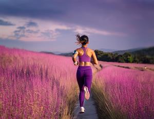 woman running through pink field 