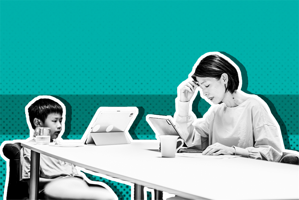 Woman and child sat at a table in front of a laptops