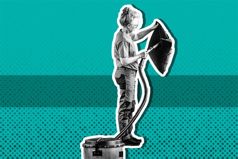 Person hoovering a cushion