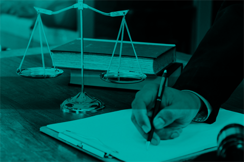 Close of hand signing a clipboard, scales and pile of books