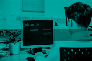 Person sat at a computer with 'job search written on the screen