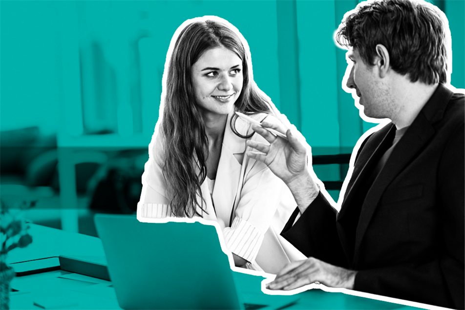 Two people at a desk smiling at each other