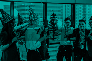 Group of people wearing Christmas hats and holding glasses and crackers