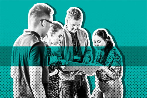 Group of people stood together with one holding a laptop