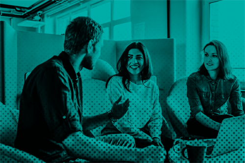 People sat talking in front of laptop