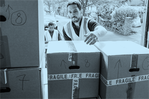 Person in a hi-vis jacket about to pick up a cardboard box
