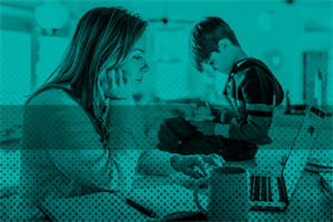 Woman in front of laptop with child sat next to her