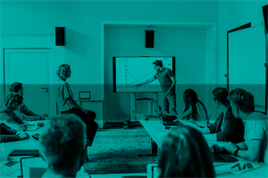 Group of people in a classroom watching someone presenting