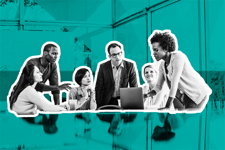 Group of people in an office gathered around a laptop