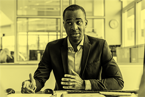 Man sat at a desk talking