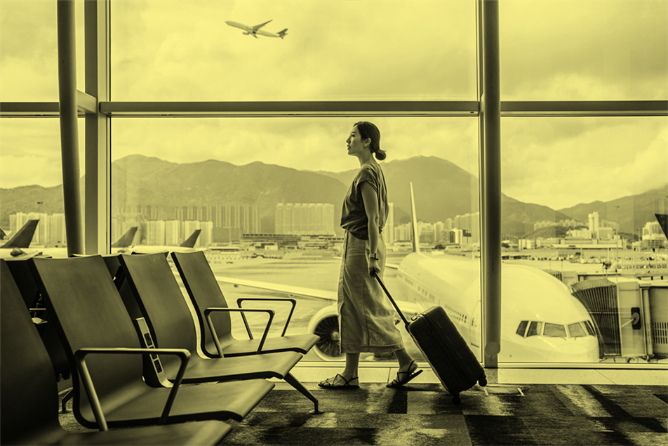 Business woman walking through airport with luggage