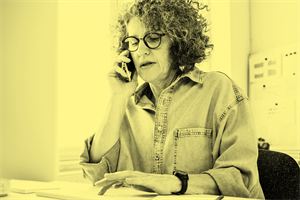 Woman sat at a desk on the phone