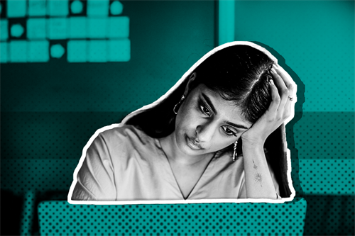 Woman sat in front of a computer screen with her head leaning on her hand