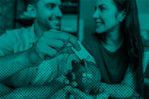 Couple putting money into piggy bank