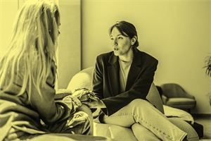 Two people sat down holding hands