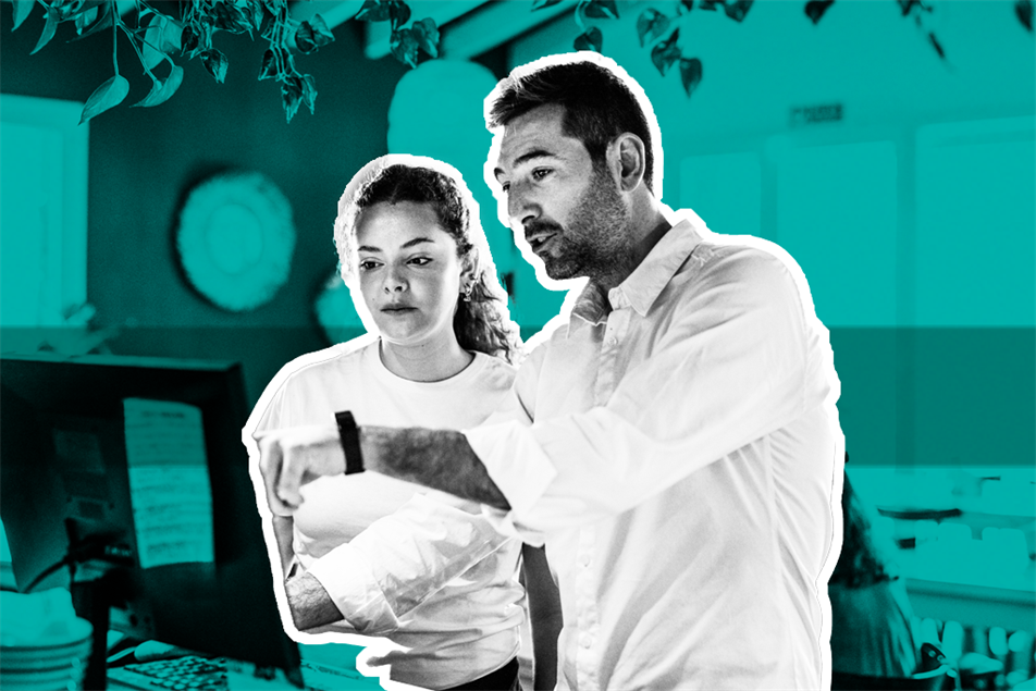 Two people stood looking at a computer screen