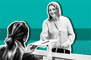 Person handing a clipboard and pen to someone sat behind a desk