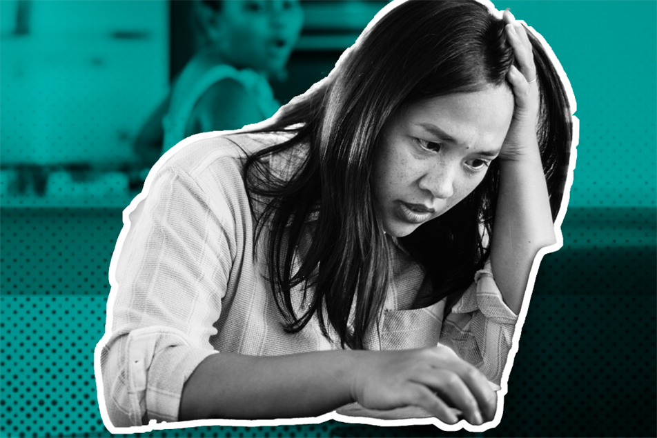 Person sat at a laptop with their hand on their head