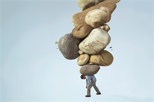 Man in smart clothes struggling to carry rocks on his back