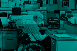 Person in a wheelchair sat at a desk