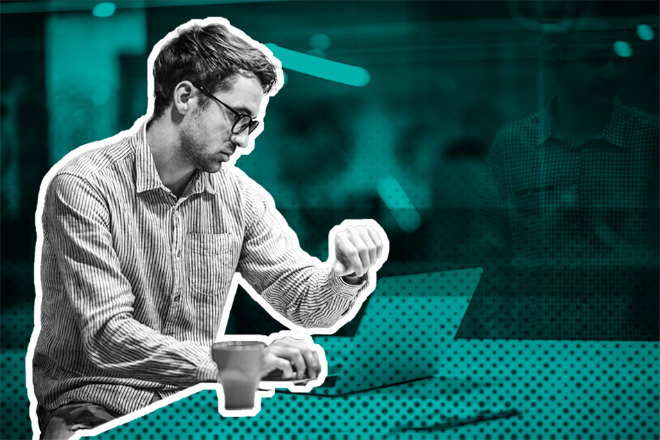 Person sat in front of laptop looking at their watch