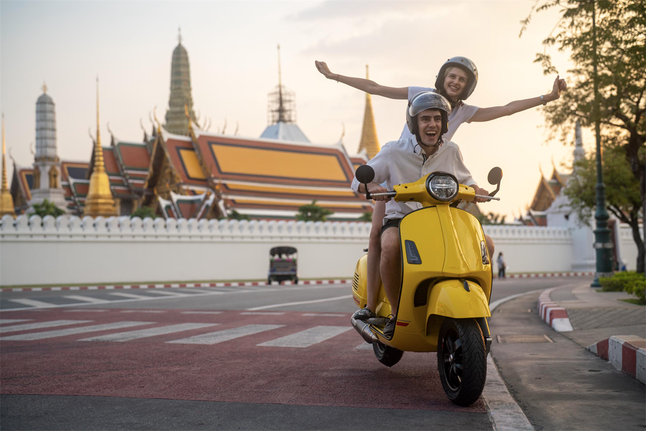 Couple driving scooter on holiday