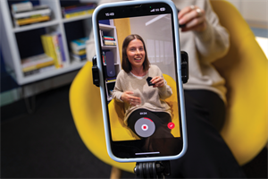 Mobile phone videoing someone sitting down